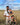 Father carrying toddler in Wildride baby carrier with daughter standing in wheat field